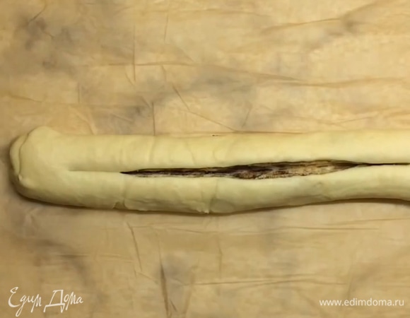 Скручиваем в плотный рулет и защипываем края. Нарезаем рулет вдоль на две половины, отступая с одной стороны 4–5 см. Плетем косичку из теста.