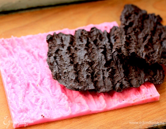 Для декора нам нужно изготовить шоколадную кору. У меня для этой цели есть силиконовый молд. Можно «пожамкать» хорошо фольгу и делать кору на ней. Шоколад нужен только темперированный! Я не буду в рецепте описывать процесс, это отдельная тема с обсуждением разных способов и температур темперирования. Темперированный шоколад заливаем на силиконовый молд или фольгу, даем стабилизироваться до полного застывания при температуре не выше 18°C. Я делала 3 заливки по 100 г шоколада заранее, т. к. процесс не очень быстрый. Готовую кору разломать продольными кусками, чтоб она повторяла изгибы торта.