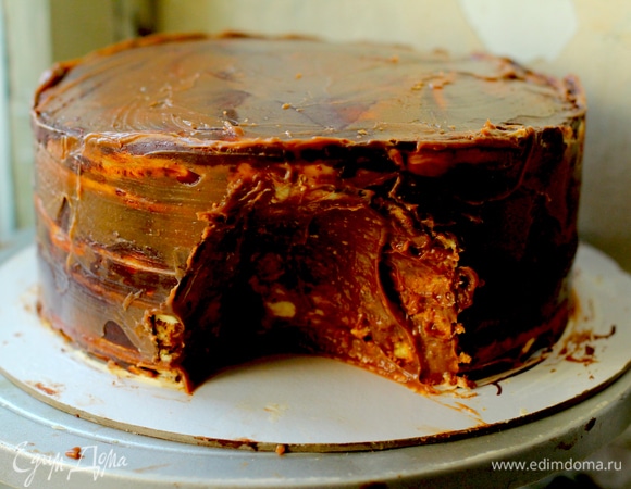 Достать отстоявшийся торт, обмазать тонким черновым слоем ганаша. Сделать ножом и ложкой «пещеру» нужной глубины.