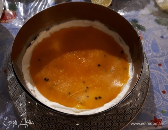 Приступим к монтажу. Отрегулируйте круг на 20 см и натяните пищевую пленку. Монтировать будем вверх ногами, так верх антреме будет максимально гладким, что необходимо для гляссажа. Выложите половину мусса, а на него — вставку из маракуйи и слегка утопите ее (но не так, чтобы она опустилась на дно).