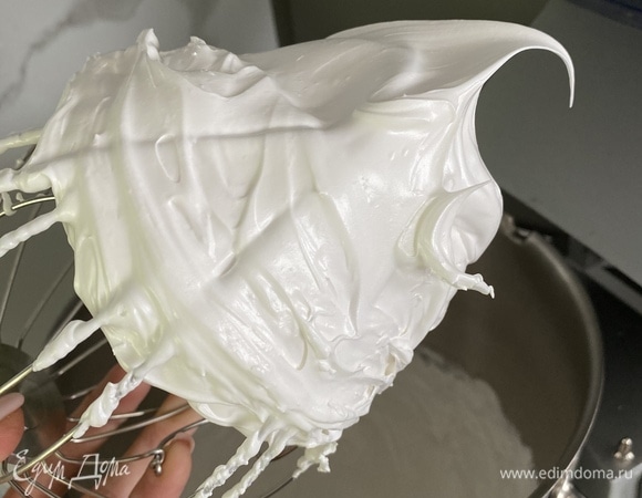 В белки комнатной температуры добавляем лимонный сок, взбиваем миксером, постепенно в процессе по ложке добавляем сахар. Должна получиться плотная масса, а сахар должен полностью раствориться. Добавить кукурузный крахмал, вымешать массу лопаткой до однородности. Духовку разогреть до 140–145°C. Противень застелить пергаментом, выложить взбитую белковую массу, разровнять и выпекать в духовке примерно 25 минут. Белки поднимаются, немного зарумяниваются, и сверху корочка появляется.