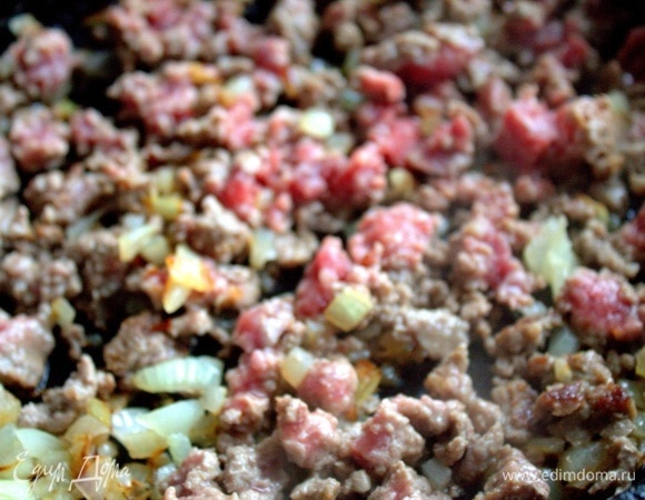 Перенести к луку размороженный фарш, быстро на огне размять вилкой.