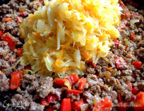 Когда фарш обжарится, всыпать к нему тушеную капусту с морковкой. Можно заменить пекинской капустой.