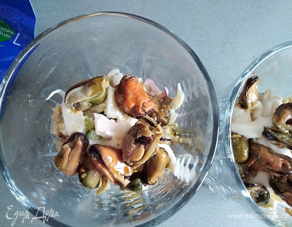 Следующий слой — мидии и снова салат, немного майонеза.