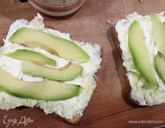 Собираем сэндвичи. Густо мажем сыром кусочки хлеба без яйца в центре, «приклеиваем» на него листья салата или пекинской капусты. Сверху еще сыр выкладываем и нарезанное слайсами авокадо. Закрываем все хлебом с яичком, посыпаем зеленью. В общем-то, все. Приятного!