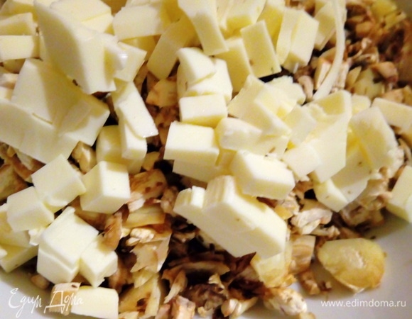 Нарезаем наши грибные ножки, нарезаем плавленый сырок кубиком, немного добавляем черного перца, добавляем немного майонеза, все перемешиваем и начиняем наши шляпки.