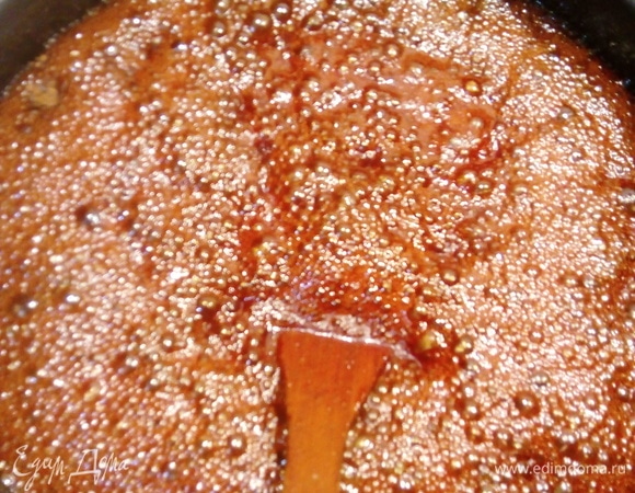 Теперь добавляем сливочное масло, аккуратно вмешиваем, потом, когда масло растворится, добавляем воду (кипяток) в несколько приемов и перемешиваем до однородности. Теперь сразу же добавляем все специи, соль и соду в нашу карамель. Смесь начнет пениться, аккуратно все перемешиваем, снимаем с плиты и оставляем остывать до температуры где-то 52°C, чтобы не свернулось яйцо при добавлении.