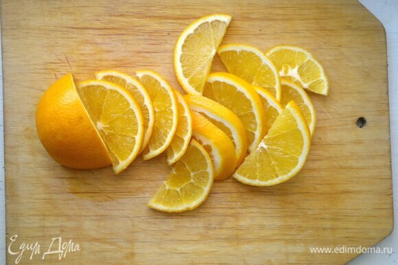 Пока тесто охлаждается, приготовить апельсиновый соус. Апельсин вымыть, обсушить, разрезать пополам и нарезать тонкими дольками.