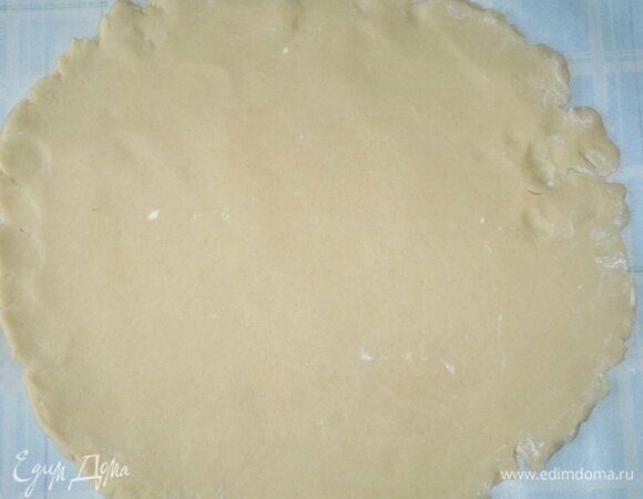 Достать тесто из холодильника и раскатать на подпыленной мукой поверхности в круг, равный диаметру дна формы с бортиками 4–5 см.