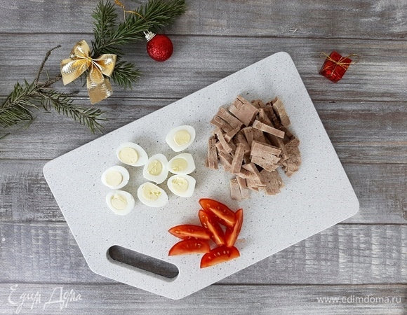 Язык тщательно моем и отвариваем до готовности (примерно 2 ч). Я солю в самом конце. Затем остужаем, чистим и нарезаем соломкой. Перепелиные яйца отвариваем в течение 5 минут. Затем заливаем холодной водой. После остывания чистим и разрезаем пополам. Томаты нарезаем дольками.