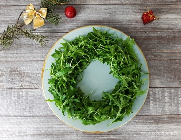 Руколу помыть и обсушить. Затем выкладываем ее на блюдо в форме кольца. Поливаем частью соуса.