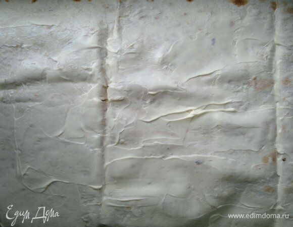 Смазать половину лаваша частью сметаны. Я использовала тонкий лаваш размером 35 х 70 см.