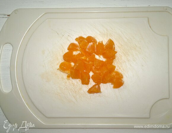 Мандарин почистить от кожуры. Удалить по возможности белые прожилки. Разрезать мандарин пополам и отрезать кружки от каждой половинки, от середины фрукта. Остальную часть мандарина нарезать на мелкие кубики.