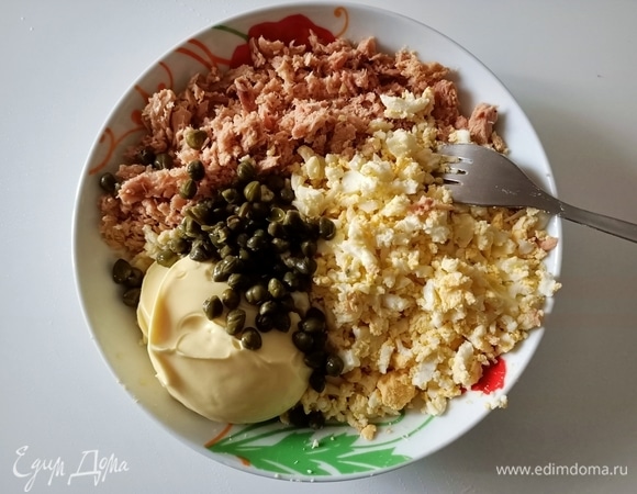 Отварить яйца, очистить и измельчить. С тунца слить жидкость, размять с помощью вилки и соединить с яйцами, добавить каперсы и майонез. Перемешать.