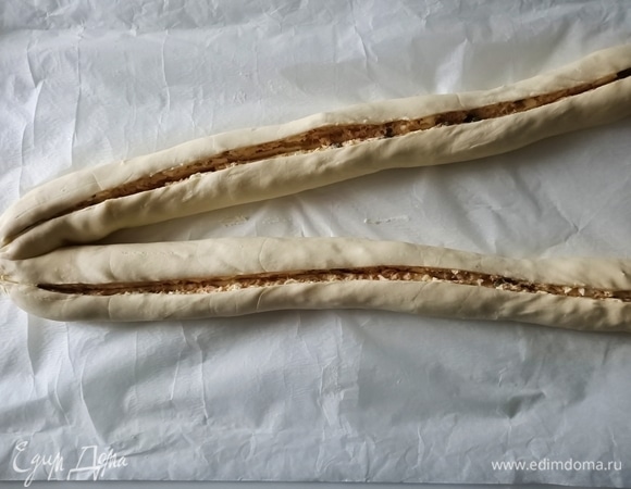 Свернуть тесто в два рулета. Закрепить концы. Сверху сделать глубокий разрез.