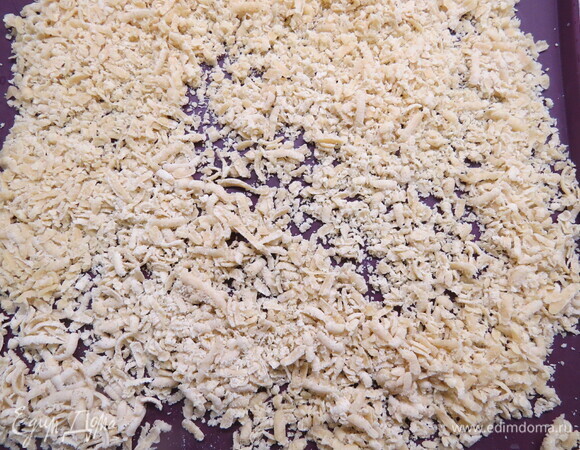 Противень застилаем пекарской бумагой. Натираем тесто на крупной терке, раскладываем его на противне слоем в 1,5 см. Выпекаем до золотистого цвета в заранее разогретой до 180°C духовке около 15–20 минут (ориентируйтесь на свою духовку). Готовому печенью даем остыть.