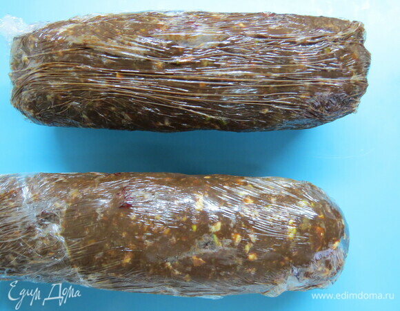 На пищевую пленку кладем часть массы из шоколада и печенья и сворачиваем колбаской. Края пленки плотно закручиваем. Убираем на пару часов (лучше на ночь) в холодильник. Готовую колбаску достаем из пленки и посыпаем со всех сторон сахарной пудрой. Я насыпаю сахарную пудру в плоскую форму для выпечки и обкатываю в ней колбаски.