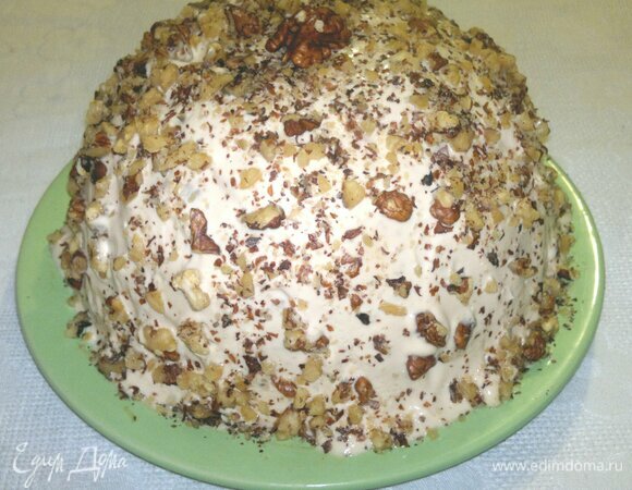 Обсыпать торт орехами. Верхушку украсить половинкой ореха. До подачи держать торт в холодильнике.
