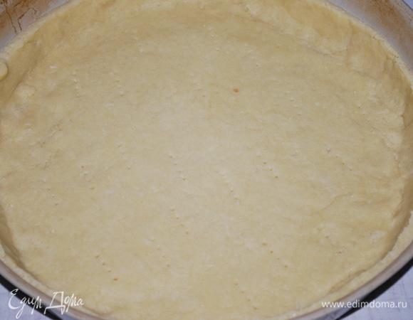 Раскатайте тесто и покройте им форму, сделайте бортики. Дно теста проткните вилкой.