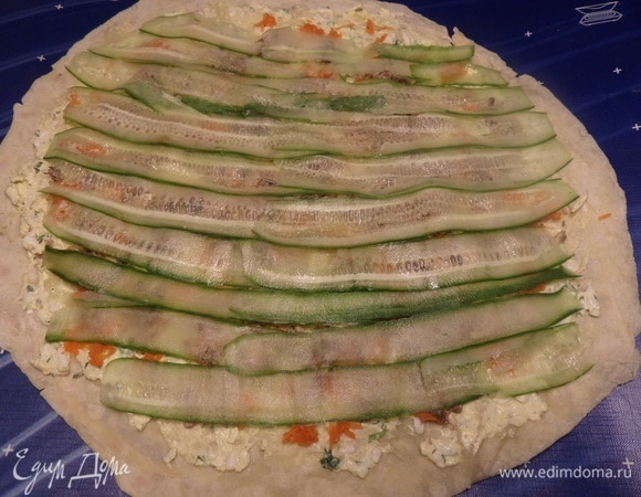 Поверх рыбы выкладываем ломтики огурца.