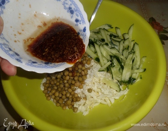 В чашку выкладываем натертый имбирь, добавляем соевый соус, растительное масло и щепотку сахара. Хорошо перемешиваем. Заправка для салата готова. В рабочую чашку выкладываем нарезанные овощи, добавляем зеленый горошек и приготовленную заправку.