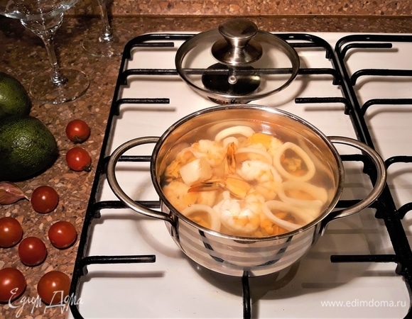 В подсоленный кипяток опустить гребешки и подержать их там 10 минут, не варить. Довести воду еще раз до кипения и отправить в кастрюльку все остальные морепродукты, в том числе 2 тигровые креветки для украшения — у них оставляем хвостик. Не варить — подержать в кипятке 3 минуты.