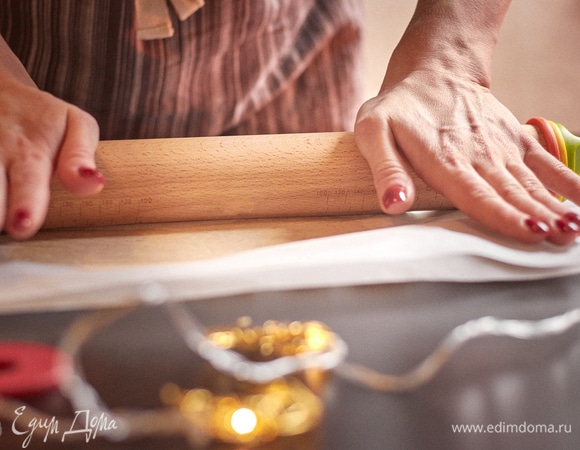 Охлажденное песочное тесто раскатать между двух листов пергамента до толщины 2 мм. Очень удобно делать это скалкой с кольцами, постепенно уменьшая их.