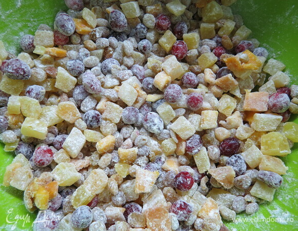 Изюм и цукаты процедить через дуршлаг, смешать с 20 г муки и ввести в тесто, перемешать.