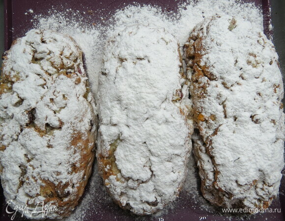 Пока штоллены выпекаются, растопить сливочное масло. Готовые горячие штоллены сразу смазать растопленным сливочным маслом и щедро посыпать сахарной пудрой.