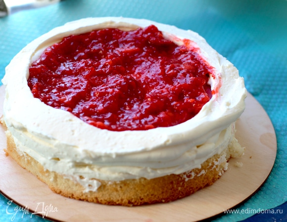 Далее продолжаем делать бортик в виде колодца — это будет место для соуса. Выкладывам половину соуса, разравниваем. Далее сборка в том же порядке: бисквит, крем, мусс, бортик из крема, соус. Накрываем все третьим бисквитом.