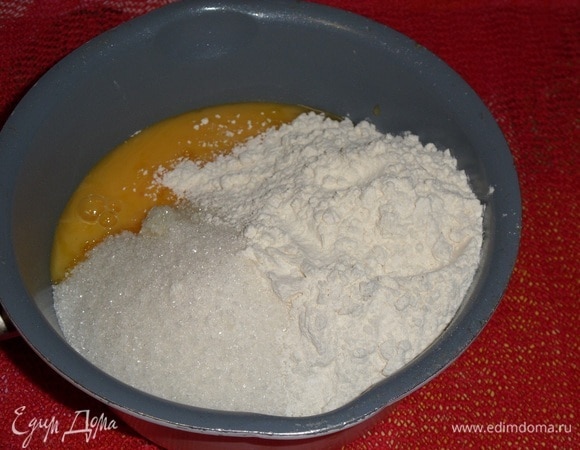 Готовим шоколадный крем. Шоколадное масло достаем из холодильника и оставляем при комнатной температуре. В кастрюлю выкладываем сметану, сахар, ванилин, желтки, муку. Хорошо перемешиваем массу.