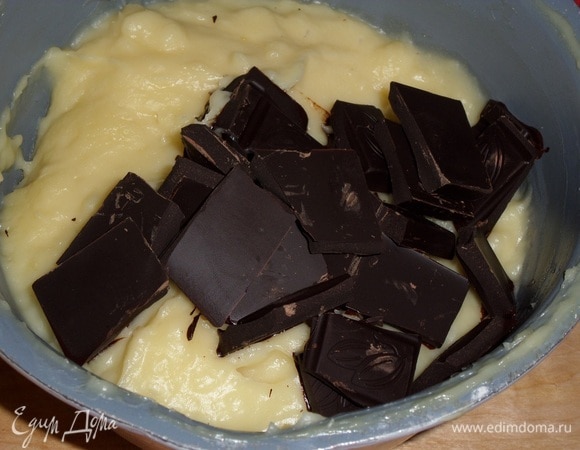 Добавляем в горячую заварную основу горький шоколад. Удобнее измельчить его. Перемешиваем массу.