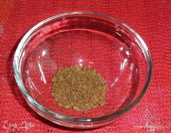 В чашечку выкладываем 1 ч. л. растворимого кофе. Добавляем 2 ст. л. горячей воды.