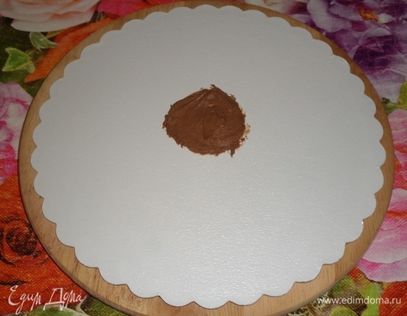 Можем приступать к сборке торта. Шоколадные бисквиты достаем из холодильника, убираем пленку. Вишневую начинку достаем из холодильника. Шоколадный крем достаем из холодильника и выкладываем в кондитерский мешок. Подложку для торта протираем салфеткой, смоченной спиртом. В центр подложки выкладываем 1 ч. л. шоколадного крема.