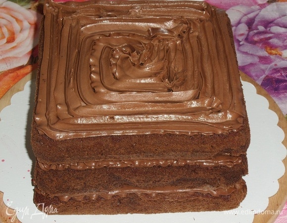 Укладываем третий шоколадный корж. Наносим крем.