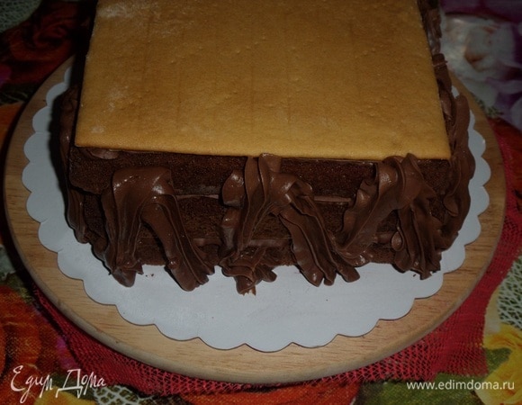 Через указанное время вынимаем шоколадный торт из холодильника, убираем пленку. Наносим на торт оставшийся шоколадный крем.