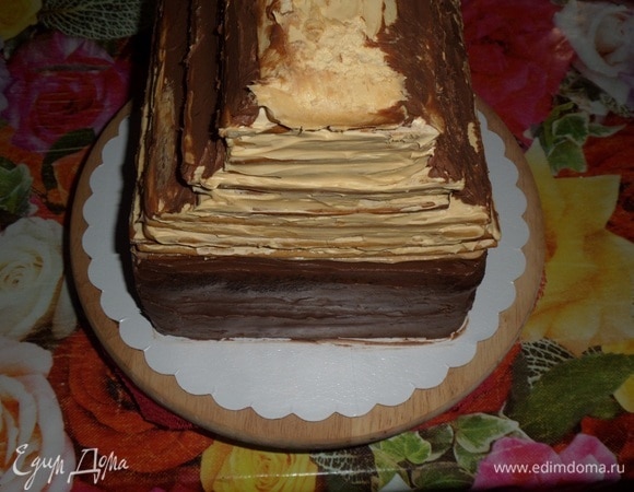 С помощью лопатки переносим медовый торт-крышу на шоколадную основу. Отправляем на 1 час в холодильник.