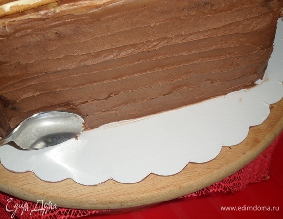 Вынимаем торт из холодильника. Ложкой делаем рисунок на шоколадной основе.