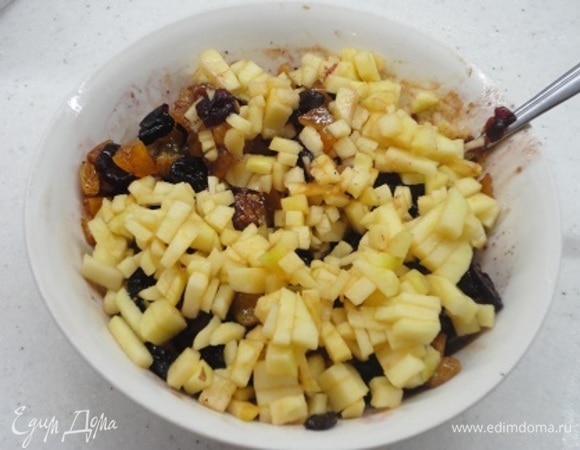 Тем временем займемся начинкой: к замоченному изюму с клюквой и вишней добавьте мелко нарезанное яблоко, апельсиновый сок и корицу. Холодное масло натрите на крупной терке и хорошо перемешайте с начинкой.