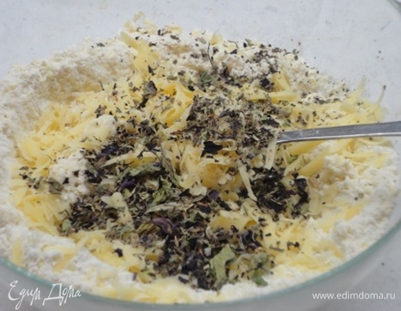Добавить любой натертый твердый сыр, оставив пару ложек для финальной посыпки, и базилик. Молока подливайте столько, чтобы получилось мягкое гладкое тесто. Долго месить руками нельзя, чтобы тесто не затянулось.
