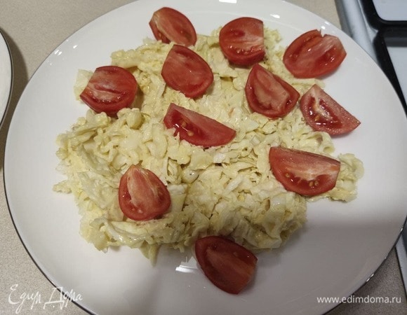 Собираем салат. В миску для подачи выкладываем пекинскую капусту, смешанную с соусом. Помидоры режем пополам или на четвертинки и добавляем в салат.