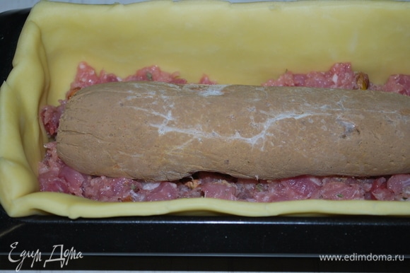 Форму до половины заполнила мясной начинкой и сверху выложила «колбаску» из паштета, чуть вдавила ее. На «колбаску» — остатки мясной начинки.