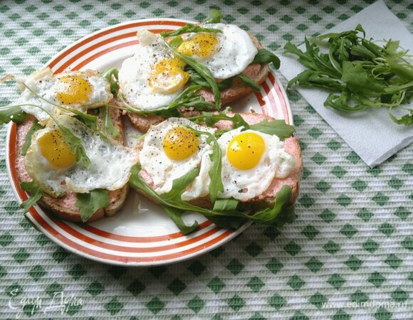 Сверху разложить на тосты жареные перепелиные яйца. Посыпать свежемолотым черным перцем. Подать тосты к столу. Приятного аппетита!