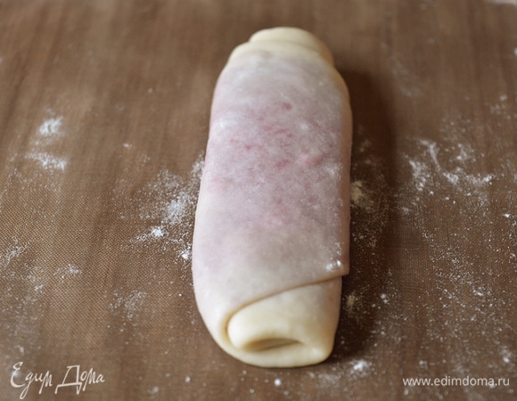 Отправляем рулет в холодильник. Такие же манипуляции проделываем с каждым шариком. В итоге в холодильнике будут лежать 11 тонких рулетиков. Берем рулет, который мы скатывали первым, и кладем перед собой узкой частью. Слегка расплющиваем его скалкой.