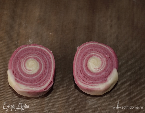 Формирование печенья. Достаем все рулеты из холодильника. Берем рулет и острым ножом режем его пополам на две одинаковые части. Округляем приплюснутые срезы. На фото рулетики стоят на внешней, витой части рулета.