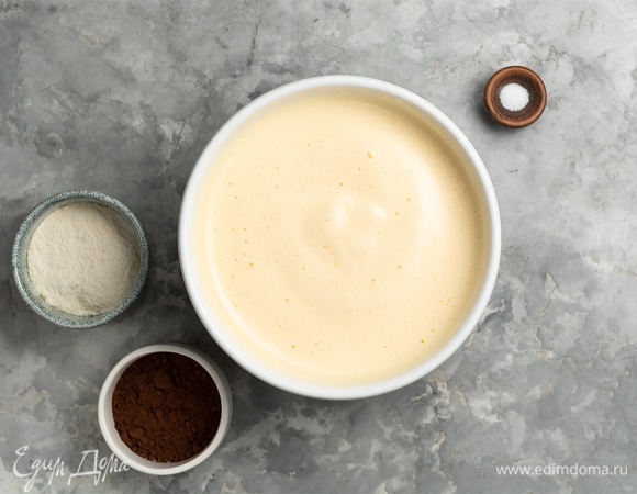 Муку и какао смешать, просеять во взбитые яйца и аккуратно лопаткой перемешать, сохраняя воздушность.