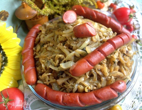 Сверху на капусту кладем сосиски.