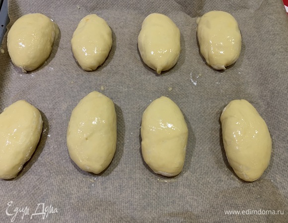 Тесто обминаем, делим на небольшие кусочки и скатываем из них шарики (у меня получилось 16 штук). Каждый шарик раскатываем в лепешку на припыленной мукой поверхности. На каждую лепешку выкладываем начинку по одной столовой ложке. Соединяем края теста и формируем пирожок.