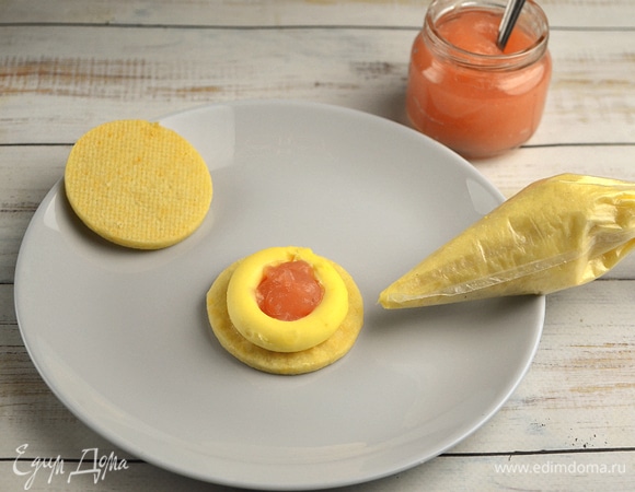 Сборка. Перекладываем крем в кондитерский мешок с круглой насадкой и отсаживаем его по кругу на каждую половинку печенья, оставив центр пустым. Яблочное пюре перекладываем в кондитерский мешок и отсаживаем в центр кольца заварного крема. Накрываем второй половинкой печенья. Всего должно получиться 32 штуки.