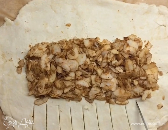 Достаем тесто и раскатываем (сразу на бумаге для выпекания), затем в середину выкладываем яблочную начинку.